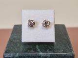 a close up of a pair of earrings sitting on top of a marble block