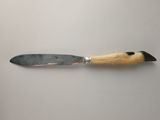 un couteau avec un manche en bois sur une surface blanche