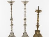 a set of three silver candlesticks on stands on a white background