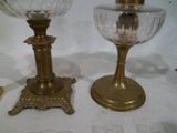 une paire de bougeoirs anciens en laiton avec des coupelles en verre, posés sur une table blanche