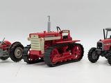 two toy tractors sitting next to each other on a white surface