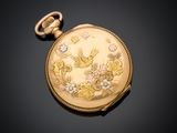a gold pocket watch with a bird and flowers on it
