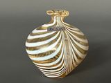 a glass vase with a gold and white design on it