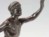 bronze statue of a woman holding a tennis racquet on a marble base