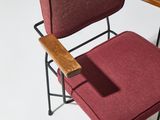 a red chair with a wooden arm rest on a white surface