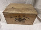 an old wooden box with a label on it sitting on a white cloth