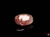 gros plan d'un diamant rose sur une surface noire