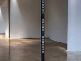 a tall black sign in the middle of a room