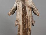 an old statue of a man with his arms spread out