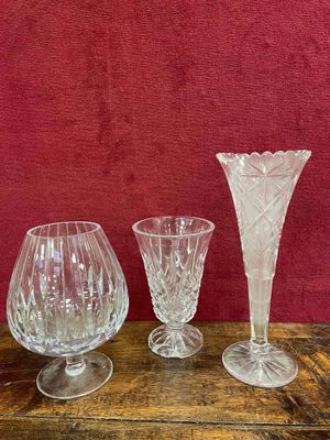 trois verres à vin posés sur une table, avec un mur rouge en arrière-plan