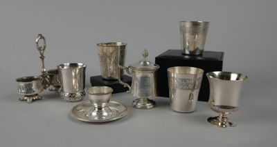 Plusieurs tasses et soucoupes en argent sont posées sur une table