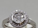 a close up of a diamond ring on a white surface