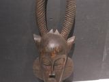 an image of a wooden mask hanging on a wall
