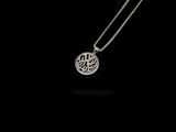 silver plated necklace with an intricate design on a black background