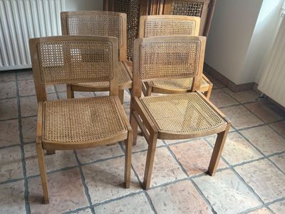four chairs sitting on a tile floor in a room