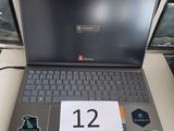 un ordinateur portable posé sur une table sur laquelle figure un numéro