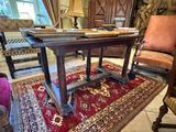 a table and chairs in a room with a red rug