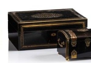two black and gold boxes sitting next to each other on a white surface