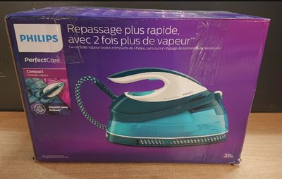packaging of a blue and white steam iron sitting on a wooden table