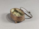 a small silver box with a ring on top of it