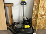 a black and yellow steam cleaner and some cleaning supplies on the floor