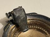 a silver plate with a hammer sticking out of it