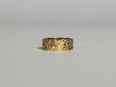 gros plan d'une bague en or sur une surface blanche