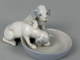 porcelain figurine of a dog and a cat sitting on a plate