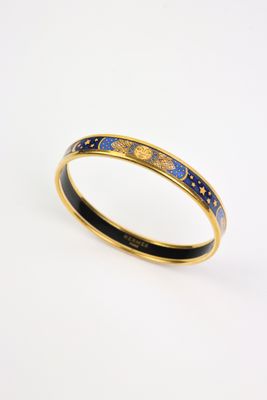 un gros plan sur un bracelet rigide en émail doré et bleu