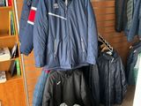 many jackets hanging on a wall in a room