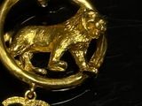 a gold necklace with a lion and a chanel charm