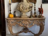 a bust of a woman sitting on a table next to a mirror