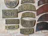 a lot of different types of leather belts on the floor