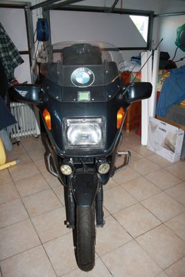 une moto noire garée dans un garage, équipée d'un radiateur