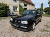 a small black car parked in front of a house