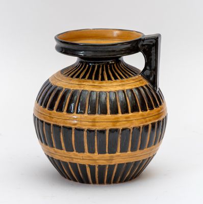 un vase noir et marron muni d'une anse, sur fond blanc