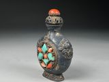 an image of a small blue vase with a red and green decoration