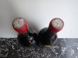 two bottles of wine that are sitting on a counter
