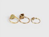 three gold rings with a green tourmaline stone
