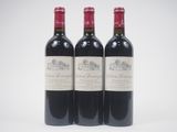 three bottles of red wine sitting next to each other on a white surface