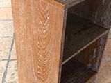 une table en bois surmontée d'une étagère, posée sur un sol carrelé
