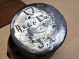 a metal container with a metal lid on a wooden table