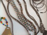 many different necklaces and bracelets displayed in a box