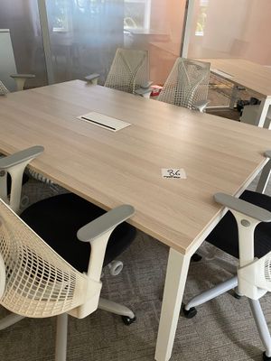 a table with chairs and a laptop on it in a room