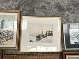 many framed pictures on the wall of this room