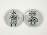 two plates with designs on them on a white surface
