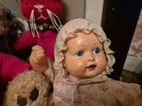 two teddy bears and a baby doll on a table