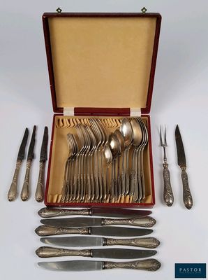 un service en argent dans un coffret rouge, comprenant des cuillères et des couteaux en argent