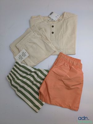 trois shorts et un t-shirt posés sur une surface blanche