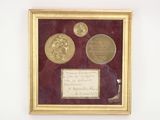 framed photograph of three gold coins and a note in a gold frame